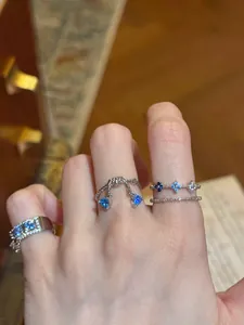 Detail view of elegant blue zircon rings featuring triangular and flower patterns.