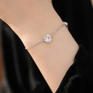 Elegant minimalist silver heart bracelet with sparkling zircon gemstone on wrist detail view