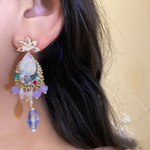 Detailed close-up view of vintage crystal teardrop dangle earrings on a model's ear