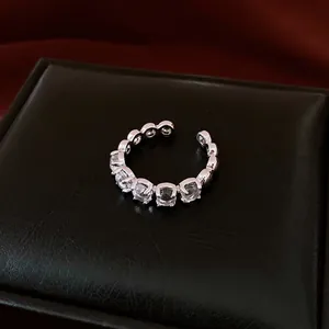 Bague ouverte réglable minimaliste avec design ajouré et accents de pierres claires