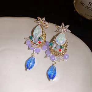 Detailed view of retro court style earrings with blue drop crystals and sparkling zirconia