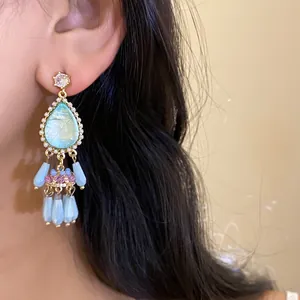 Detailed view of vintage palace style water-drop tassel earrings with light blue beads