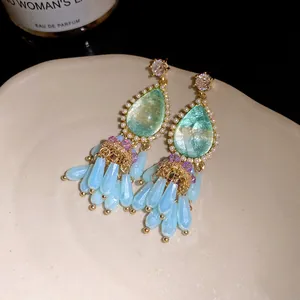 Detailed view of vintage palace style teardrop earrings with light blue crystal fringes