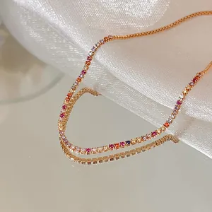 Close-up of gold-plated bracelet with colorful cubic zirconia on satin background