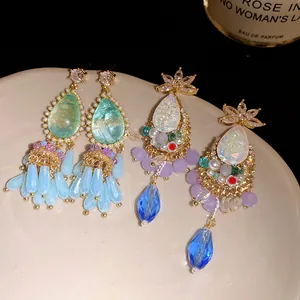 Detail of vintage court style earrings with teardrop crystals and colorful tassels.