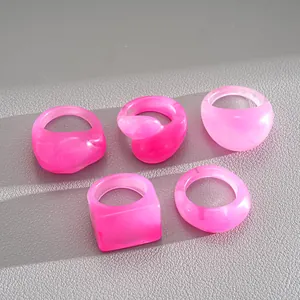 Detail shot of five vibrant pink resin rings in various geometric and square shapes