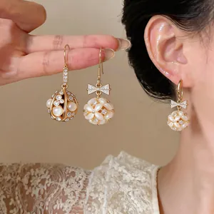 Close-up detail of 14k gold plated earrings with bowknot and cat's eye stones