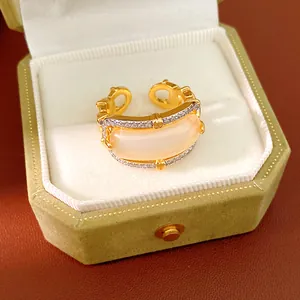 Detail shot of a gold zircon ring with pink sugar cube stone in a green velvet box