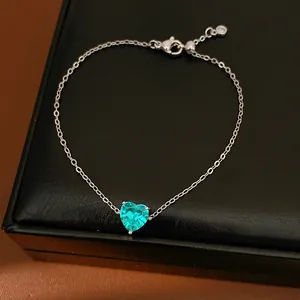 Close-up of a silver chain featuring a brilliant heart-shaped turquoise zircon pendant