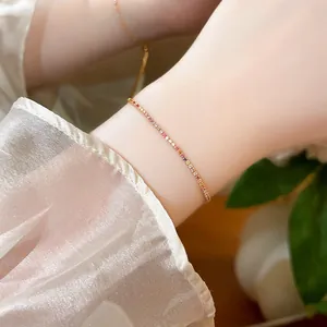 Close-up of a delicate 18k gold plated bracelet with colorful zircons on a wrist