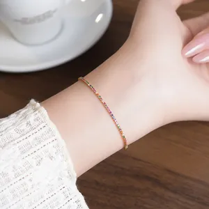 Close-up of a delicate 18k gold plated rainbow zircon bracelet on a feminine wrist