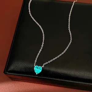 Close-up of vibrant turquoise heart-shaped zircon pendant on a delicate silver chain
