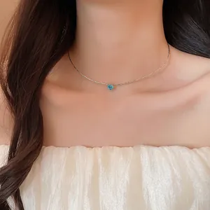 Detailed view of a delicate heart-shaped blue zircon pendant necklace on a silver choker.