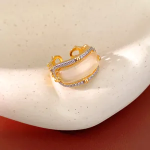 Macro detail of a vintage gold-plated ring featuring zircon pavé and a cat's eye stone.