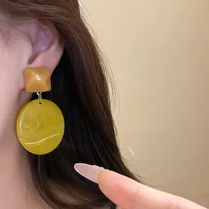 Close-up detail of vintage resin geometric drop earrings in khaki and olive green marble