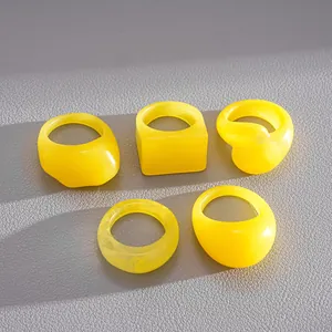 Macro view of five yellow resin geometric rings with square and round shapes