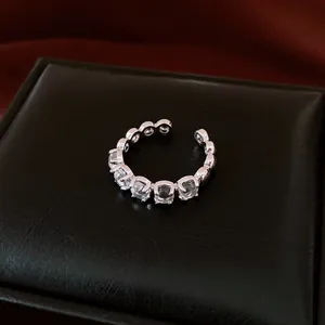 Vue détaillée d'une bague ouverte minimaliste en argent sertie de pierres claires.