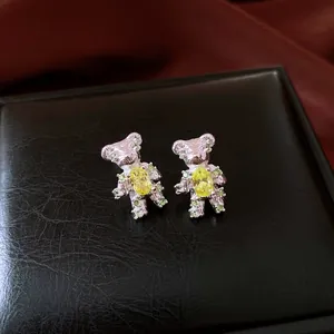 Macro shot of cute bear stud earrings with yellow stone and silver needle finish