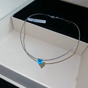 Detailed view of a blue heart zircon pendant necklace resting in a sleek jewelry box.