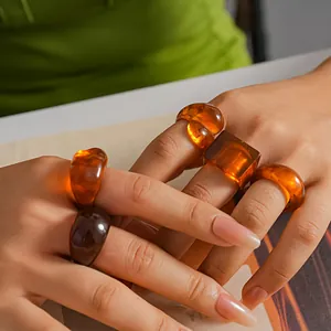 Close-up detail of five geometric amber resin rings in square and round shapes for women