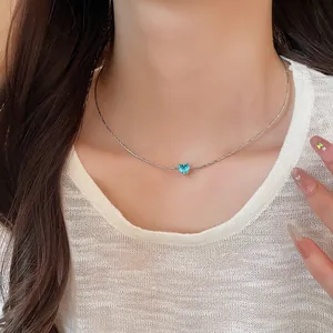 Close-up of a French style necklace with a light blue heart-shaped zircon pendant