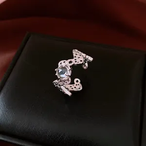 Vue macro de la bague évidée argentée montrant les détails et la pierre précieuse claire
