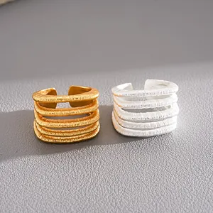 Primer plano de anillos abiertos texturizados multicapa con elegantes acabados oro y plata