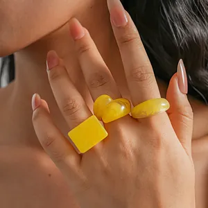 Chunky yellow resin geometric ring set featuring heart and square shapes on model