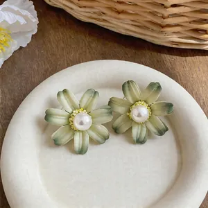 Detailed macro view of French style fabric flower earrings featuring a white pearl center