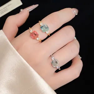 Macro detail view of three elegant zircon rings in various colors on a model's hand.