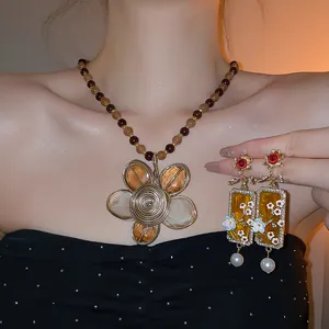 Primo piano di set di gioielli vintage con collana di fiori e orecchini floreali