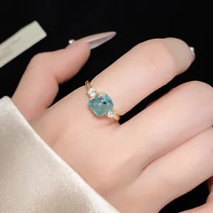 Detailed shot of an elegant gold-plated ring featuring a square light blue zircon stone.