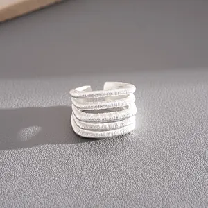 Primer plano de la textura metálica de este anillo abierto multicapa en color plateado