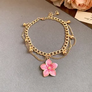 Elegant gold-tone multi-layer anklet featuring a pink drip oil flower pendant and charms