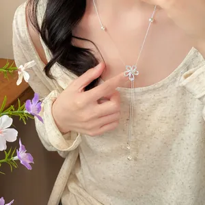 Elegant silver zircon hollow flower long necklace with pearl accents worn by model