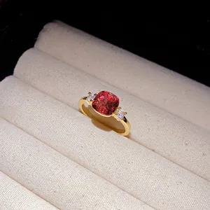 Close-up detail of an elegant gold ring with a square red gemstone in a jewelry box