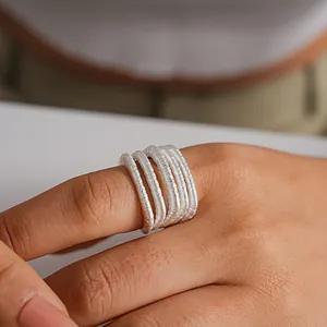 Vista macro detallada que muestra la textura de un anillo abierto multicapa de plata