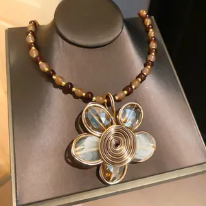Primo piano del ciondolo a forma di fiore fatto a mano con cristalli su collana