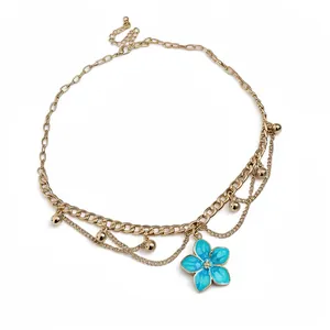 Elegant vintage gold-plated necklace with a vibrant blue enamel flower pendant detail.