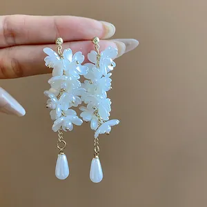 Detailed close-up of French style white flower tassel earrings with pearl drops