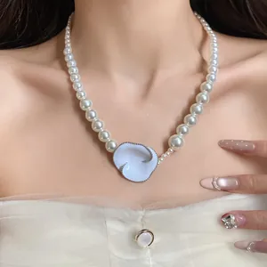 Dettaglio della collana di perle stile francese con ciondolo a fiore in smalto bianco