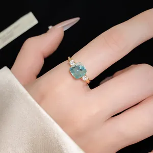 Macro detail of elegant gold-plated ring featuring a square blue zircon gemstone