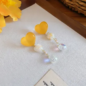 Vintage yellow heart tassel earrings featuring iridescent charms on elegant fabric