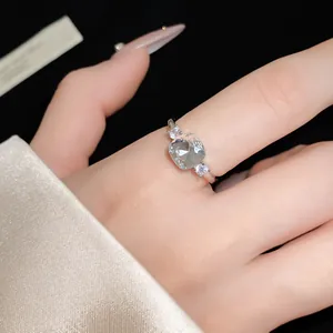Detailed view of an elegant silver open ring with a square zircon on woman's finger