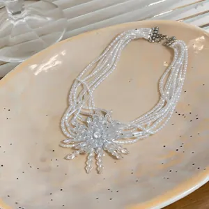 Detail view of a French vintage multi-strand pearl necklace with a firework crystal pendant.