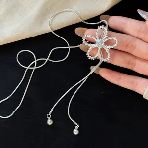 Close-up of a zircon hollow flower pendant on a silver snake chain necklace