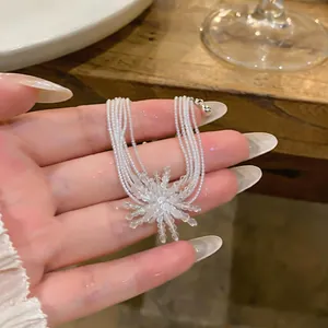 Detailed view of firework-shaped pearl necklace pendant and multi-strand design