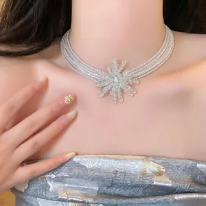 Detail view of a French vintage multi-layer pearl necklace with a snowflake pendant.