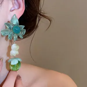 Summer style teal floral drop earrings with translucent petals and marble green bead.
