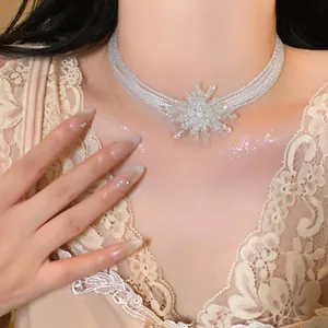 Detailed view of an elegant white beaded necklace featuring a crystal snowflake pendant
